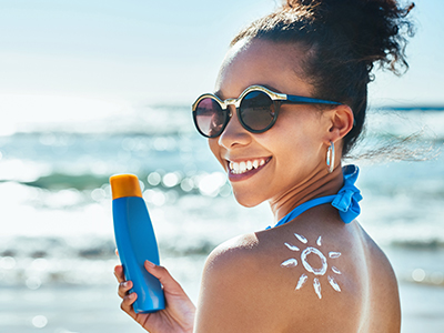 Sunscreen inhibits the formation of vitamin D from the Sun. Young woman with a sunscreen cream